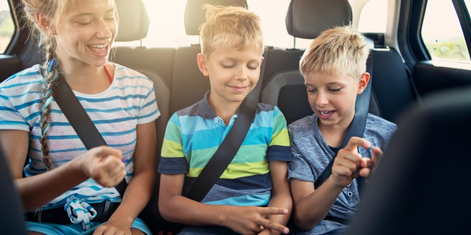 Kids playing games in car during road trip