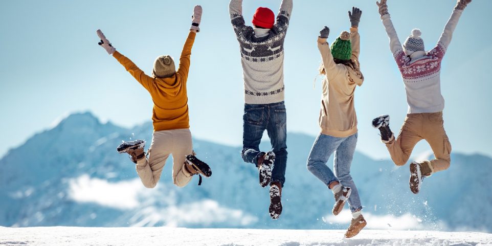 Friends celebrates beginning of winter in mountains, jumps and having fun, and engaging in kids winter break activities